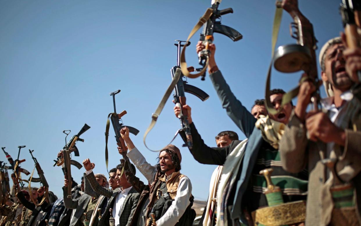 Tribesmen loyal to Houthi rebels hold up their weapons as they attend a gathering to show their support for the ongoing peace talks being held in Sweden - AP
