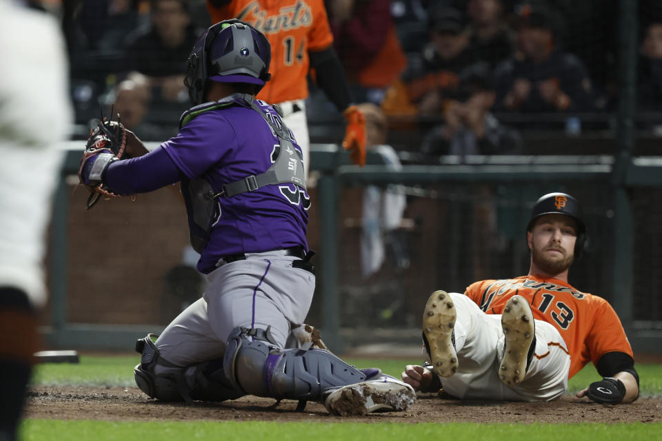 Colorado Rockies catcher Elias Diaz holds the ball after tagging out San Francisco Giants' Austin Slater (13) during the sixth inning of a baseball game in San Francisco, Friday, July 7, 2023. (AP Photo/Josie Lepe)