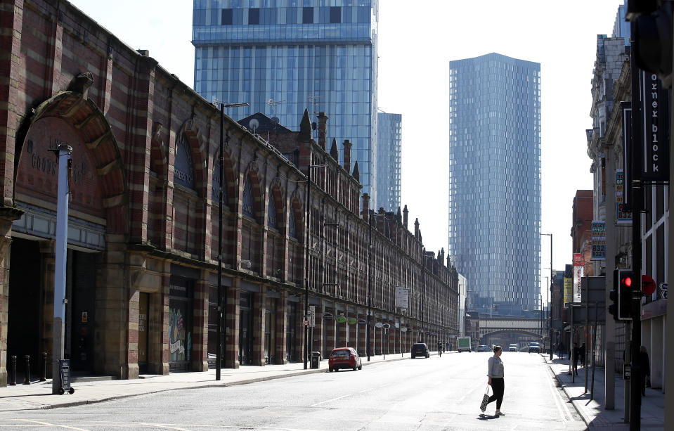 A woman walks down a deserted Deansgate in Manchester after Prime Minister Boris Johnson has put the UK in lockdown to help curb the spread of the coronavirus.