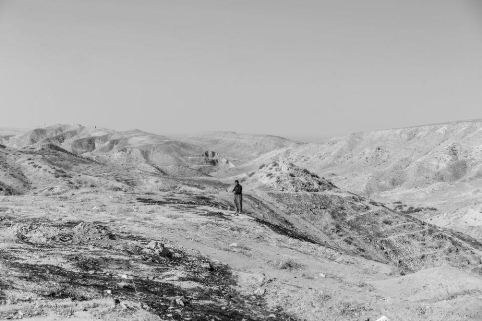 A Kurdish man prays on a hill near the Bardarash camp on Oct. 31. | Moises Saman—Magnum Photos for TIME