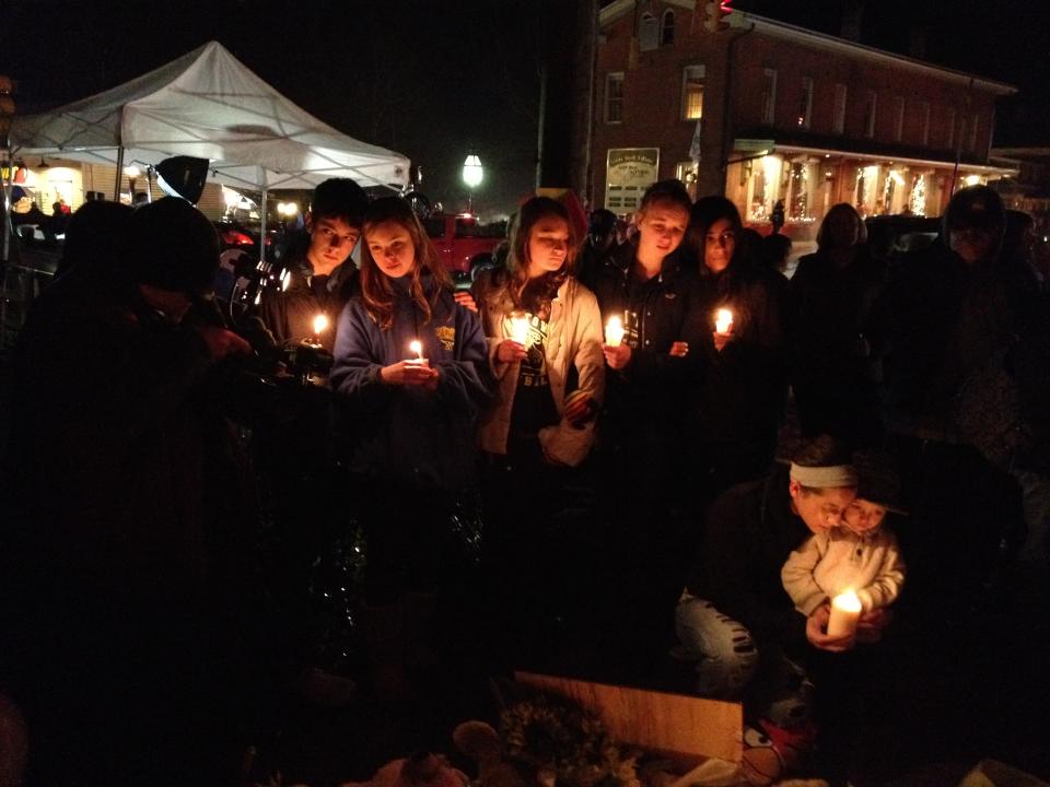 Children and parents gather in the evening at a makeshift memorial in Newtown, Conn.