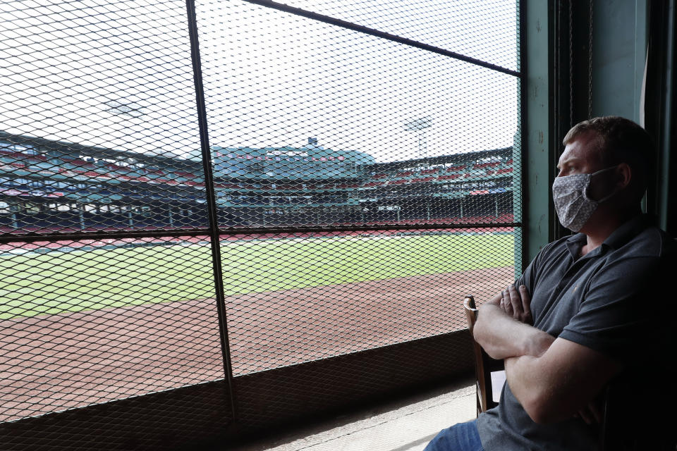 In this June 25, 2020, photo, Joe Hicks, Bleacher Bar director of operations, looks out at Fenway Park from the bar in Boston. Tucked under the center field seats at Fenway Park, down some stairs from Lansdowne Street in an area previously used as the visiting team’s batting cage, is a sports bar that is preparing to reopen from the coronavirus shutdown. If Major League Baseball’s plans remain on schedule, it may be one of the few places fans will be able to watch a game in person this season. (AP Photo/Elise Amendola)