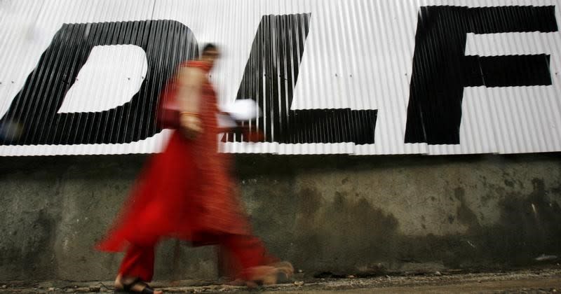 A woman walks past a billboard of Indian property developer DLF Ltd in Mumbai. Photo: REUTERS/Arko Datta (INDIA)