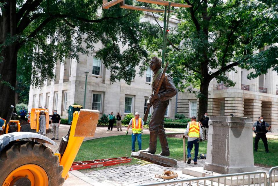 Crews remove The Henry Wyatt Monument at the North Carolina State Capitol in Raleigh, N.C., Saturday, June 20, 2020.