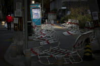 A resident carries groceries walks by barricades laying around a closed coronavirus testing site in Beijing, Sunday, Nov. 27, 2022. Protests against China's overzealous zero-COVID policies in Shanghai continued on Saturday afternoon, after police cleared away hundreds of protesters in the early morning hours with force and pepper spray. (AP Photo/Andy Wong)