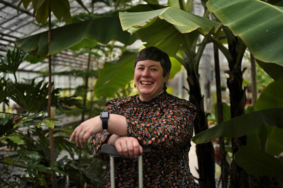University of Maine climate scientist Jacquelyn Gill poses in one of the school's greenhouses, Wednesday, May 4, 2022, in Orono, Maine. While most climate change news is gloomy, many scientists like Gill have found ways to remain optimistic about the future. (AP Photo/Robert F. Bukaty)