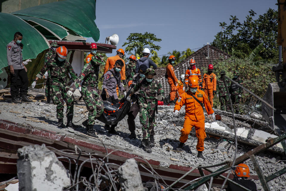 <p>Indonesian soldiers and search and rescue teams carry the body of a victim from a collapsed mosque following earthquake in Tanjung on Aug. 7, 2018 in Lombok Island, Indonesia. (Photo: Ulet Ifansasti/Getty Images) </p>