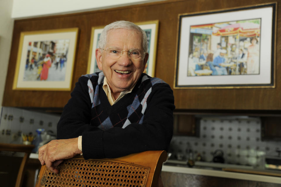 In this Wednesday, Feb. 26, 2014 photo, actor, artist and singer Robert Clary poses near some of his paintings at his home in Beverly Hills, Calif. Clary, who starred in the sitcom “Hogan’s Heroes,” turns 88 on Saturday, March 1, 2014. (Photo by Chris Pizzello/Invision/AP)