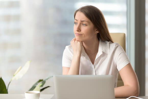 Woman at laptop looking to the side as if distracted