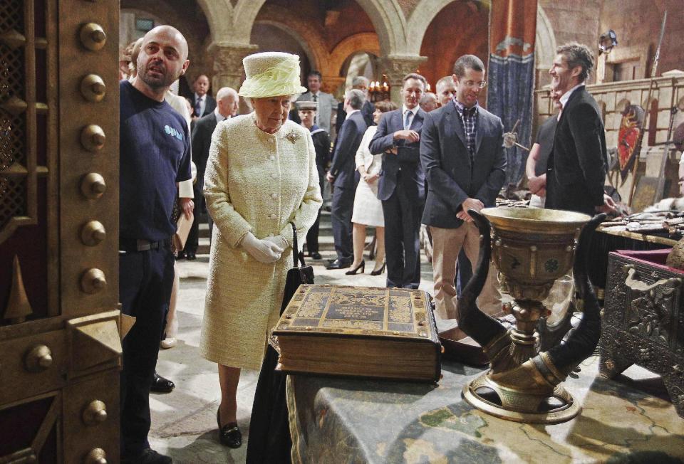 Britain's Queen Elizabeth looks at props as she visits the set of TV series Game of Thrones, in Belfast