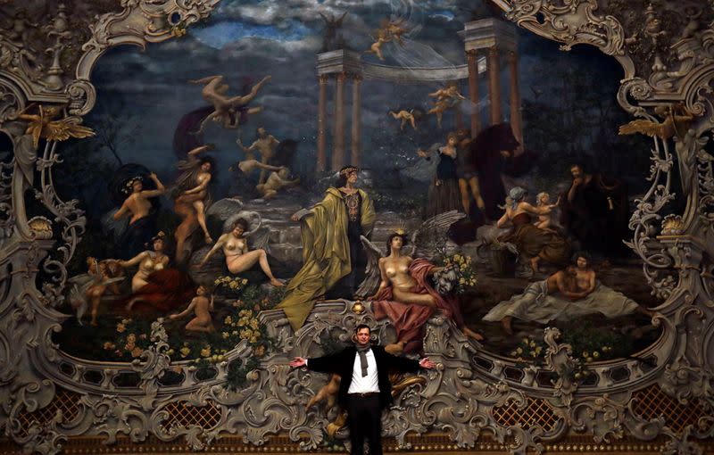 Czech painter Martin Cerny poses in front of a newly installed curtain during a general renovation of Prague's State Opera building
