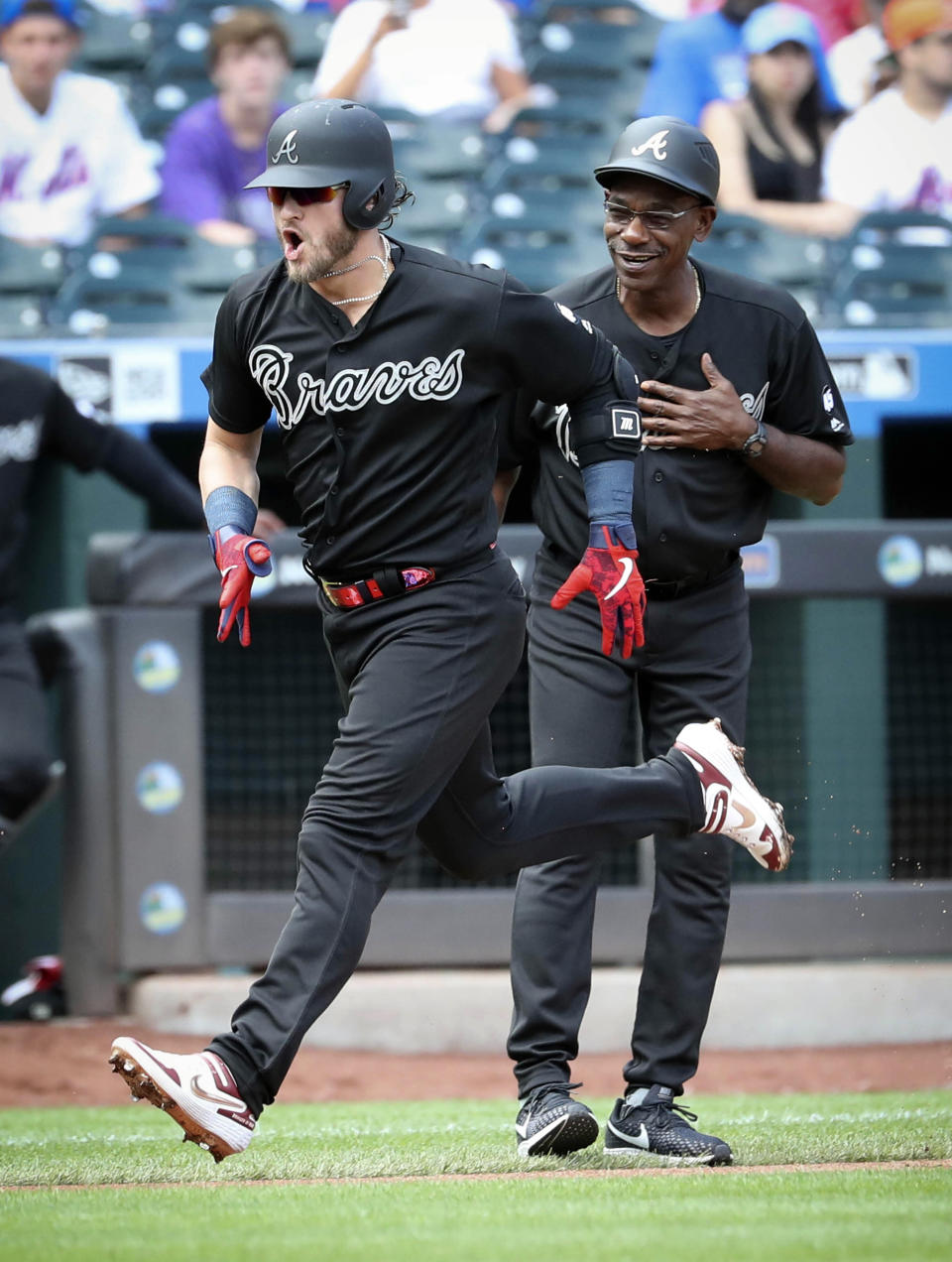 Atlanta Braves third base coach Ron Washington, right, cheers Josh Donaldson who runs the bases after a home run during a baseball game against the New York Mets, Sunday Aug. 25, 2019, in New York. (AP Photo/Bebeto Matthews)