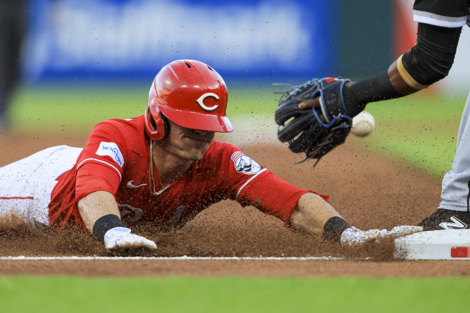 Cincinnati Reds' TJ Friedl, left, who hit an RBI-double, slides into third base as Chicago White Sox's Hanser Alberto fields the throw during the third inning of a baseball game in Cincinnati, Friday, May 5, 2023. Friedl overslide the base and was tagged out by Alberto. (AP Photo/Aaron Doster)