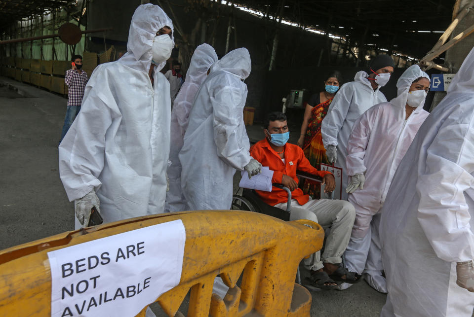 Medical staff in front of a sign saying 'beds not available'. Source: AP