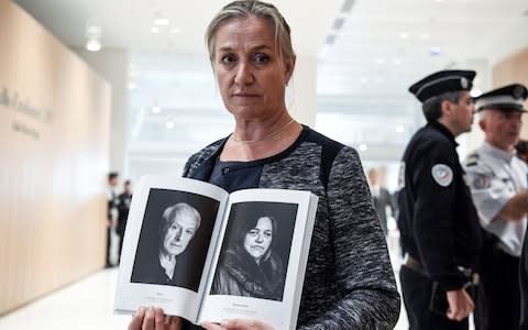 French pulmonologist Irene Frachon poses with a photobook depicting portraits of "mediator victims" as she arrives on September 23, 2019 at Paris' courthouse - Credit: AFP/BERTRAND GUAY