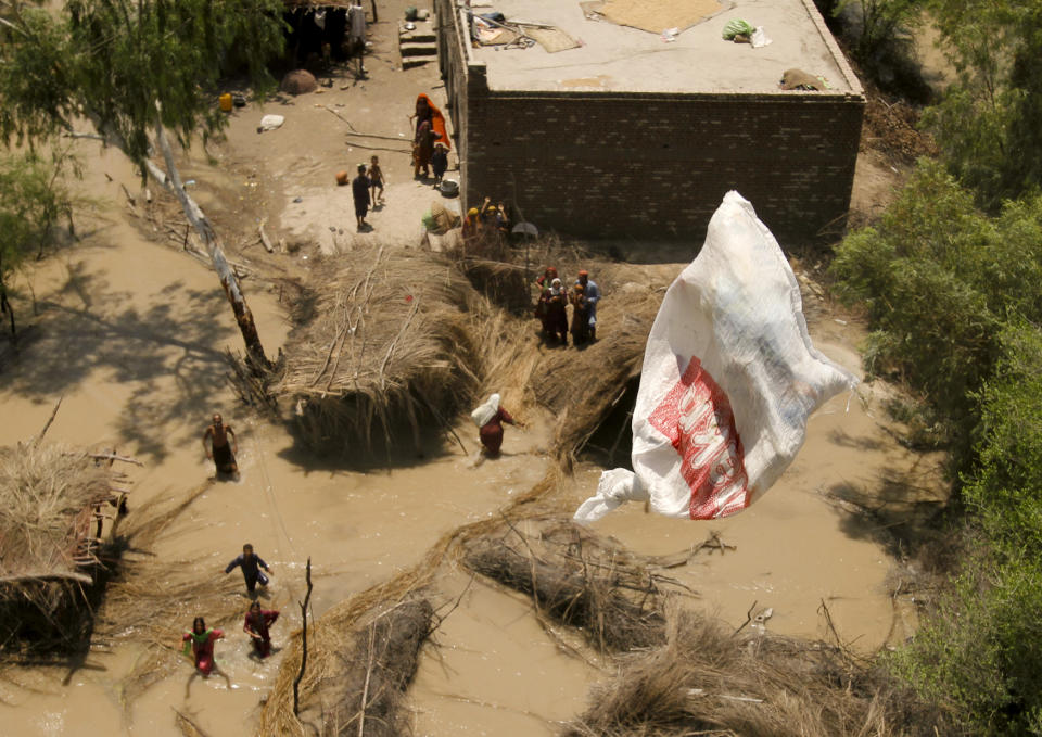 <p>Pakistani villagers chase relief supplies dropped from a Pakistani navy helicopter at a flooded area of Ghaus Pur near Sukkur, in Pakistan’s Sindh province, Aug. 11, 2010. (AP Photo/Shakil Adil) </p>