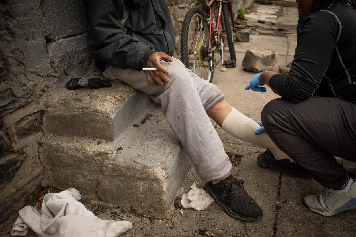 Lydia Williams, a certified wound care nurse, rebinds a patient's wounds during her shift offering street-side medical services throughout Kensington in Philadelphia, on April 27, 2023.