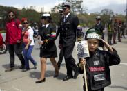 Zeus Malaver, 5, poses for a photo holding a portrait of Venezuela's former President Hugo Chavez at a military parade commemorating the one year anniversary of Chavez's death in Caracas, Venezuela, Wednesday, March 5, 2014. The anniversary of Chavez's death was marked with a mix of street protests and solemn commemorations that reflected deep divisions over the Venezuela he left behind. (AP Photo/Rodrigo Abd)