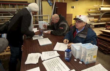 A Flint resident (L ) picks up a replacement water filter at a fire station in Flint, Michigan January 13, 2016. REUTERS/Rebecca Cook