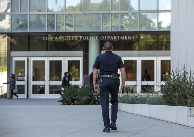 LOS ANGELES, CA - OCTOBER 14, 2021: A member of the LAPD makes his way into their headquarters on 1st St. in downtown Los Angeles. Los Angeles will officially require its city workers to be vaccinated against COVID-19 as the vaccination and reporting rules become "conditions of city employment," according to its ordinance. But it remains unclear what will happen to those who have refused to get the shots. (Mel Melcon / Los Angeles Times)