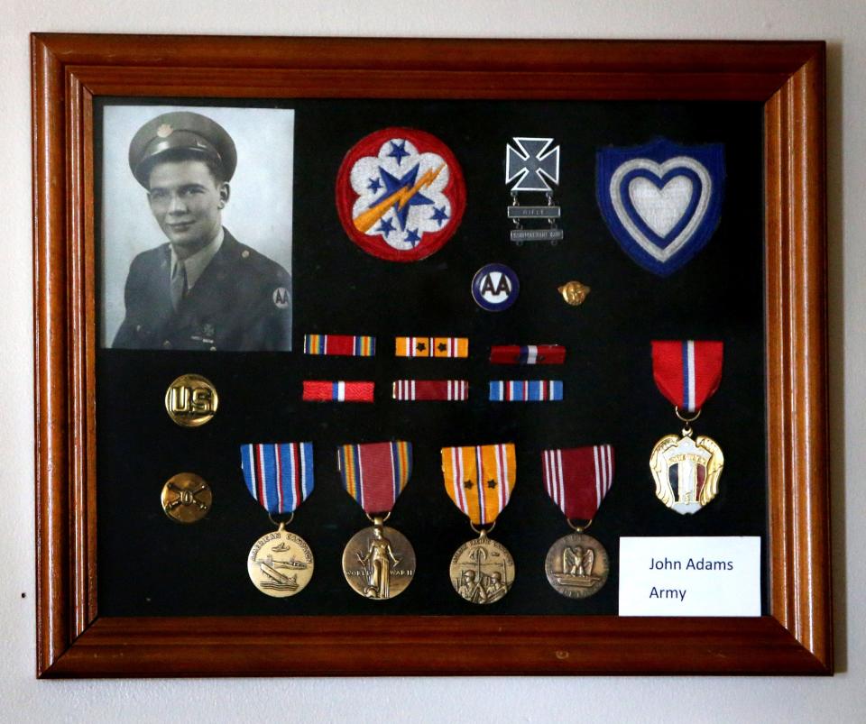 John Adams' war medals are framed over his chair at his home in Plain Township. The World War II veteran, who turned 98 this week and is in hospice care, is among a dwindling number of Americans who fought in the war.