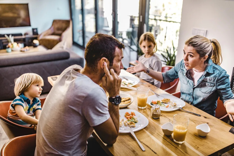 A couple arguing at the table with their children