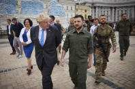 FILE - In this image provided by the Ukrainian Presidential Press Office, Ukrainian President Volodymyr Zelenskyy, centre, and Britain's Prime Minister Boris Johnson walk on the square where damaged Russian military vehicles are displayed in Kyiv, Ukraine, Friday, June 17, 2022. (Ukrainian Presidential Press Office via AP, File)