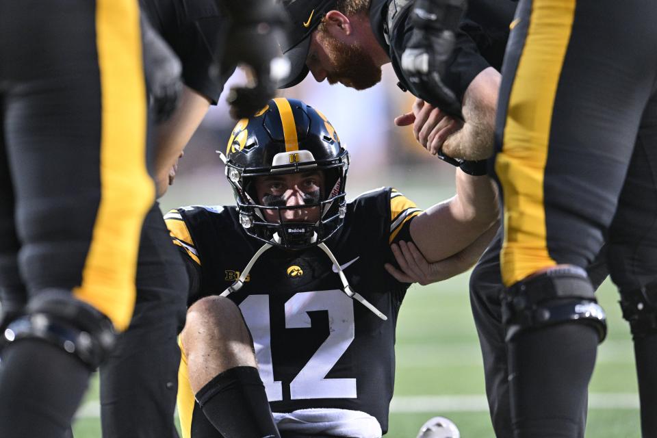 Iowa Hawkeyes quarterback Cade McNamara (12) sits on the ground after suffering an injury during the first quarter against the Michigan State Spartans at Kinnick Stadium in Iowa City, Iowa, on Saturday, Sept. 30, 2023.