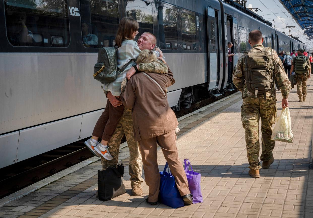 A Ukrainian serviceman hugs his wife and the daughter at the railway station in Sloviansk (AP)