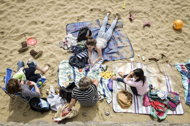 People enjoy the beach at Barry Island, in Wales, as most of England and Wales will enjoy sunshine and warm conditions over the next three days as forecasters predict temperatures could reach as high as 24C (75.2F) in London on Wednesday - 10C (50F) above the average for the time of year. PRESS ASSOCIATION Photo. Picture date: Monday April, 13, 2015. See PA story WEATHER Spring. Photo credit should read: Ben Birchall/PA Wire