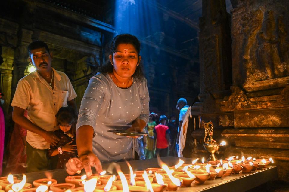 A devotee holds an oil lamp while offering prayers during Hindu festival of Diwali at a temple in Colombo, Sri Lanka on Oct. 24, 2022.