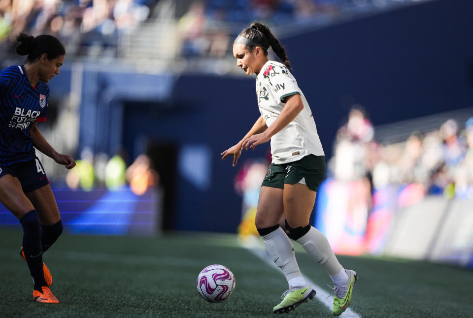 Portland Thorns forward Sophia Smith, right, maneuvers the ball against OL Reign defender Alana Cook (4) during the first half of an NWSL soccer match, Saturday, June 3, 2023, in Seattle. (AP Photo/Lindsey Wasson)