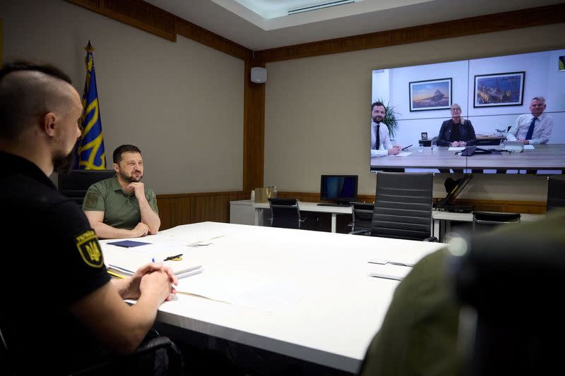 Ukraine's President Zelenskiy speaks with representatives of the BAE Systems via video call in Kyiv