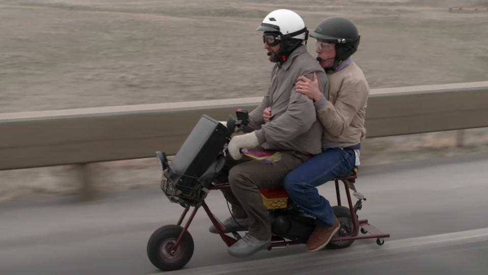 Two men ride a mini motor bike like the one seen in Dumb and Dumber