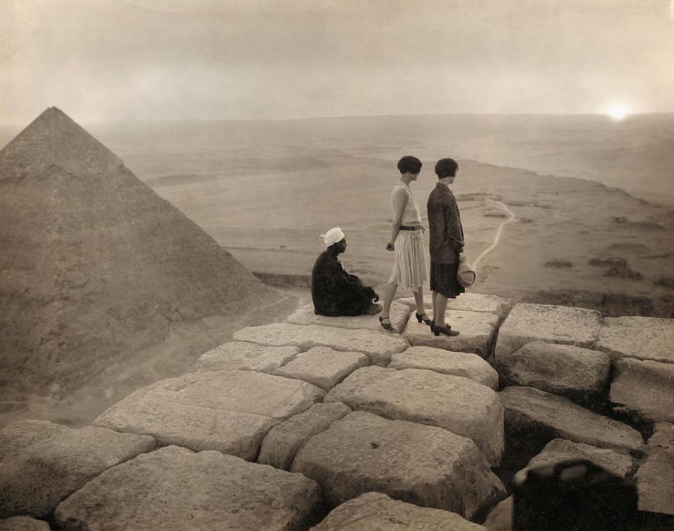 <p>Tourists soak up the view of the Sahara Desert atop a Great Pyramid in Egypt.</p>