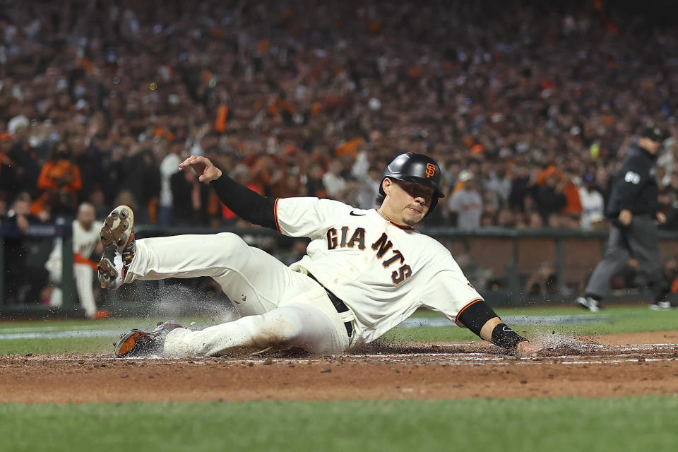 San Francisco Giants' Wilmer Flores scores against the Los Angeles Dodgers during the second inning of Game 2 of a baseball National League Division Series Saturday, Oct. 9, 2021, in San Francisco. (AP Photo/John Hefti)