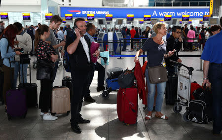 People wait with their luggage at the British Airways check in desks at Heathrow Terminal 5 in London, Britain May 28, 2017. REUTERS/Neil Hall