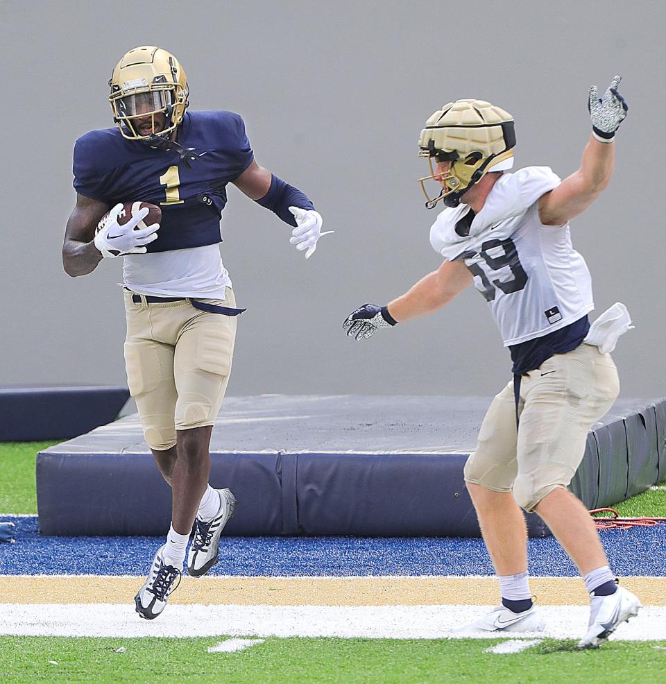 University of Akron's Daniel George looks to keep his feet in bounds after a catch in front of Andrew Behm on Aug. 15 in Akron.