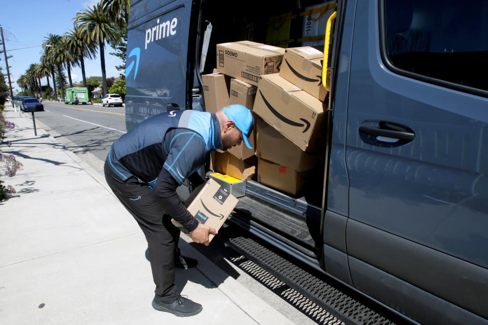 Joseph Alvarado picks up a package while making deliveries for Amazon during the outbreak of the coronavirus disease (COVID-19) in Costa Mesa, California, U.S., March 23, 2020.      REUTERS/Alex Gallardo