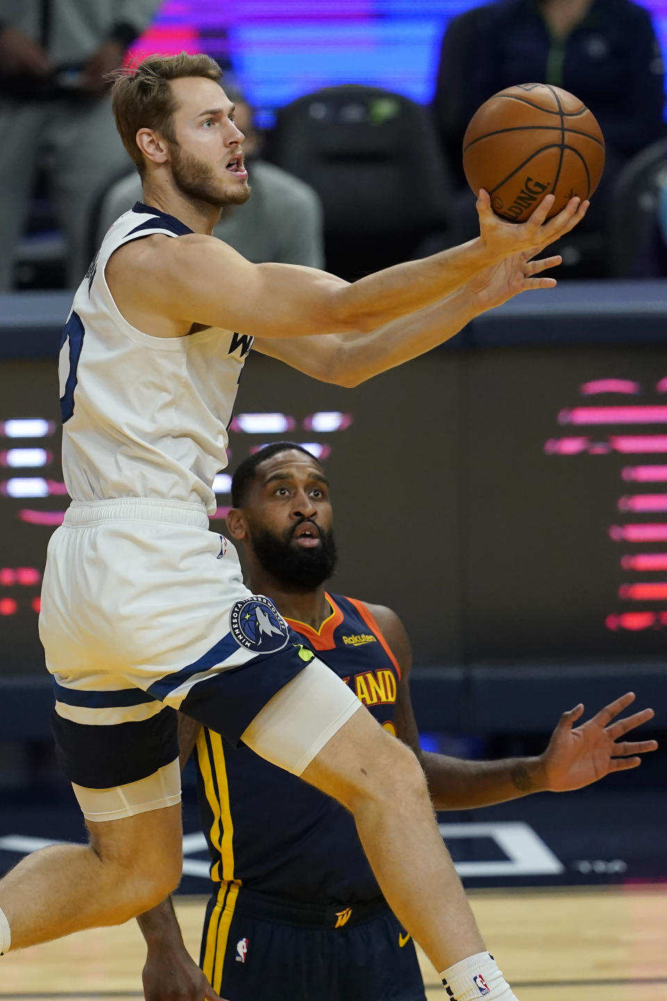 Minnesota Timberwolves forward Jake Layman, top, shoots over Golden State Warriors guard Brad Wanamaker during the first half of an NBA basketball game in San Francisco, Monday, Jan. 25, 2021. (AP Photo/Jeff Chiu)