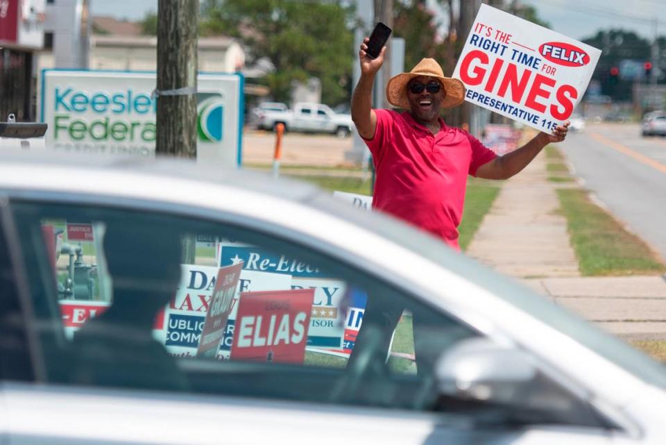 Felix Gines, a candidate for state house representative, waves to a motorist outside a polling location at D’Iberville Civic Center in D’Iberville during the Mississippi Primary Election on Tuesday, Aug. 8, 2023.