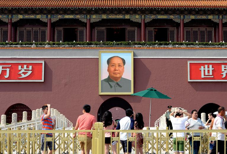 Tourists gather in front of the portrait of Mao Zedong in Tiananmen Square in Beijing on June 3, 2014