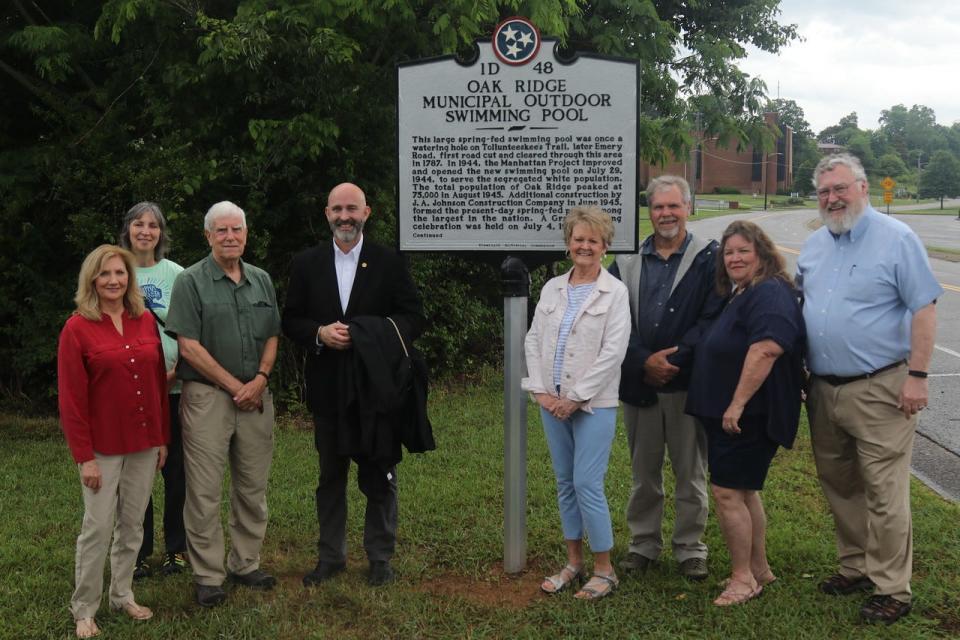 Posing with the new historical marker for the Oak Ridge Municipal Outdoor Swimming Pool are Oak Ridge Heritage and Preservation Association members Myra Mansfield, from left, Karla Mullins, Terry Domm, Jim Dodson, Sharon Harris, Mick Wiest, Bobbie Martin and D. Ray Smith.