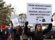 Demonstrators hold anti-Tesla posters during a protest against plans by U.S. electric vehicle pioneer Tesla to build its first European factory and design center near Berli