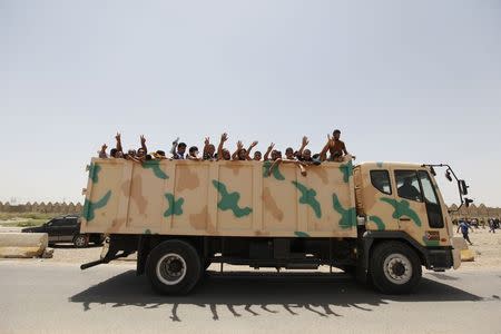 Volunteers who have joined the Iraqi army to fight against the predominantly Sunni militants, who have taken over Mosul and other Northern provinces, travel in an army truck, in Baghdad, June 12, 2014. REUTERS/Ahmed Saad