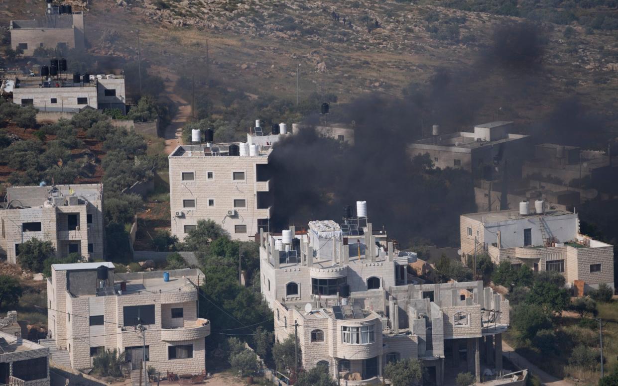 Smoke fills the sky after Israeli settlers set fire to the properties of Palestinian villagers in the West Bank village of al-Mughayyir, Saturday, April 13, 2024. Israel's army says the body of a missing Israeli teen has been found in the occupied West Bank after he was killed in a "terrorist attack." The disappearance of 14-year-old Binyamin Achimair sparked a large attack by settlers on the Palestinian village on Friday and Saturday. (AP Photo/Nasser Nasser)