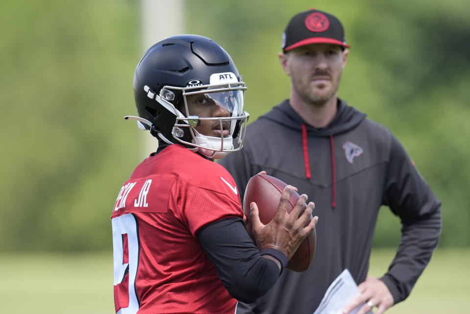 Atlanta Falcons first-round quarterback Michael Penix Jr. runs a passing drill as quarterback coach TJ Yates looks on during an NFL rookie minicamp football practice , Friday, May 10, 2024, in Flowery Branch, Ga. (AP Photo/John Bazemore)