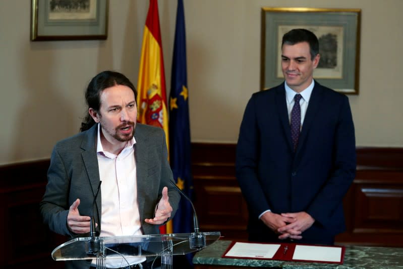 El presidente del gobierno en funciones de España, Pedro Sánchez, y el líder de Unidas Podemos, Pablo Iglesias, firman un acuerdo de coalición durante una conferencia de prensa en el Congreso de los Diputados en Madrid