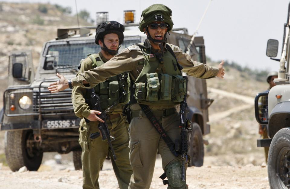 Israeli soldiers patrol the West Bank City of Hebron June 13, 2014. Israeli forces are searching for three Jewish teenagers who went missing in the occupied West Bank late on Thursday, the military said on Friday. As media speculated that the trio might have been abducted, large numbers of Israeli soldiers scoured the countryside around the flashpoint city of Hebron, carrying out house-to-house searches in neighbouring villages and blocking roads. REUTERS/Mussa Qawasma (WEST BANK - Tags: POLITICS CIVIL UNREST MILITARY)