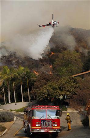 A helicopter makes a water drop on the Colby Fire in Glendora, California January 16, 2014. REUTERS/Mario Anzuoni